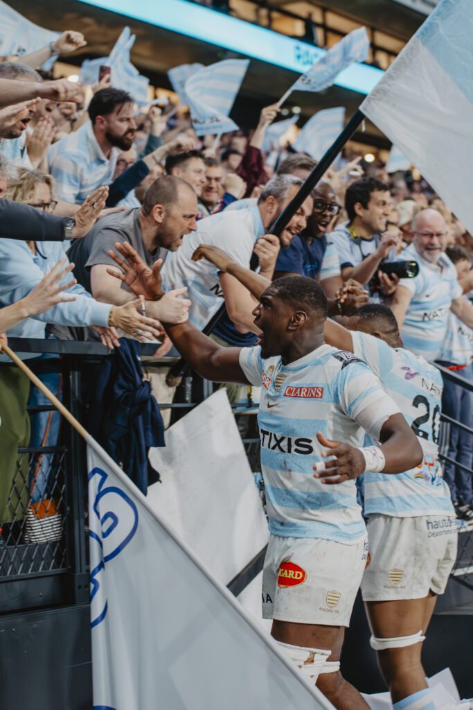 Photo de joueurs du Racing 92 célébrant leur victoire contre le stade français avec les supporters
