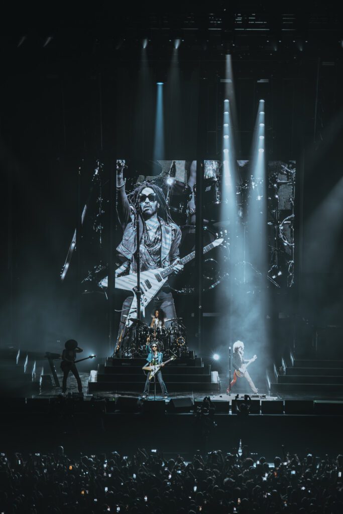 Lenny Kravitz sur scène devant un écran en noir et blanc