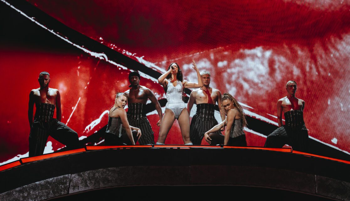 Dua Lipa Paris La Défense Arena en concert fond rouge avec danseurs